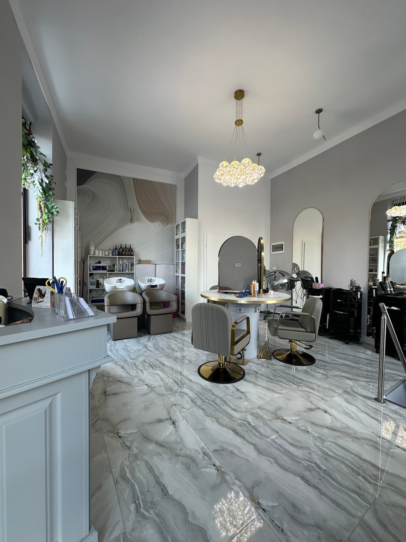 Interior elegant al salonului L'Studio hair, cu lustră și oglinzi mari