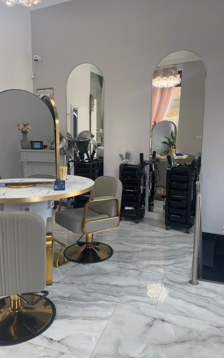 Interior salon cu podea de marmură și rafturi cu produse de styling